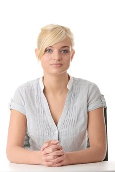 Young teen woman sitting behind the desk isolated