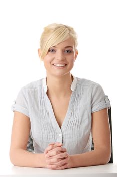 Young teen woman sitting behind the desk isolated