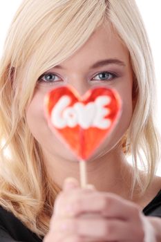Teenage girl holding red heart shaped lollipop isolated