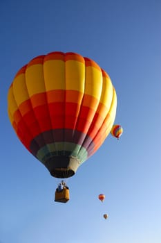 colorful balloon rising at dawn in the cold air at the Taos hot air balloon festival