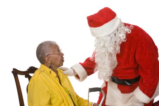 Pleasant middle-aged bearded man in a santa suit talking to an elderly lady sitting in a chair isolated on a white background