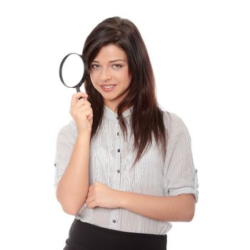 Young attractive smiling business woman looking into a magnifying glass, isolated on white background