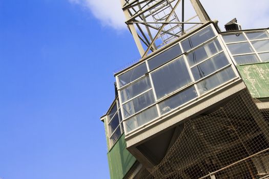 Bottom view of crane against blue sky.