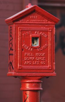Old fire alarm switch on the street in an industrial area of San Francisco, vandalized with grafitti written on it