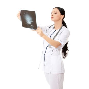 Portrait of thoughtful female doctor in uniform looking at the x-ray image. Isolated on white background
