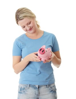 Young blond woman trying to get money from her piggy bank, isolated on white background