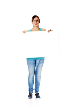 Young smiling girl in glasses holding sheet of paper. Isolated on white.