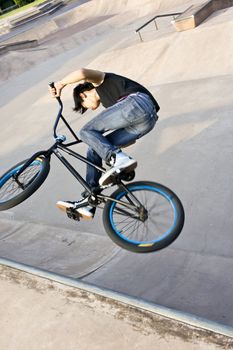 Asian Teenage boy on stunt bike in mid air