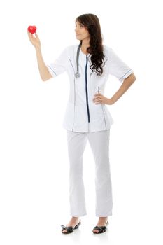 Young female doctor or nurse holding heart shaped toy, isolated on white