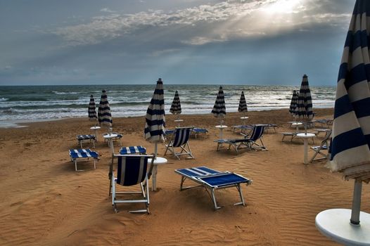 Beach with deckchairs, umbrellas and dramatic sky