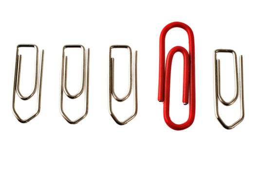 Red paper clip among a row of metal paper clips