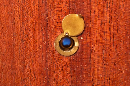 Peephole on peeling wooden door