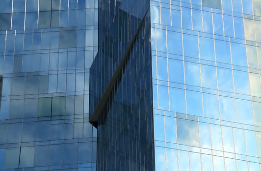 Business building, blue glass, clouded sky reflections
