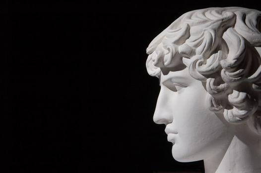 Plaster head of sculpture, black background