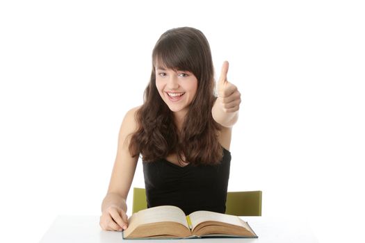 Teen girl learning at the desk gesturing, isolated on white