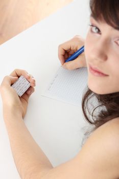 Young caucasian female student stands by school desk and cheat