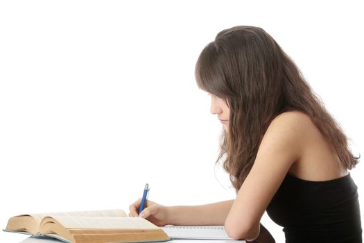Teen girl learning at the desk, isolated on white
