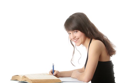 Teen girl learning at the desk, isolated on white