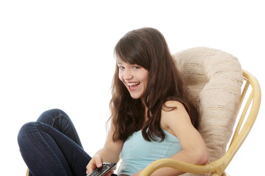 Teen woman watching TV with remote control while sitting on armchair view from TV