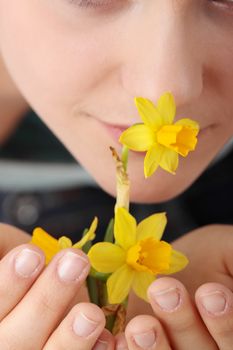 Teen girl smelling yellow spring flowers