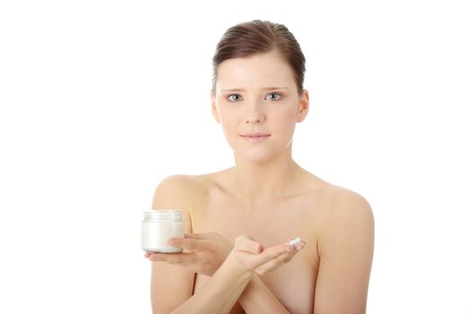 Woman applying moisturizer cream on face. Close-up fresh woman face.