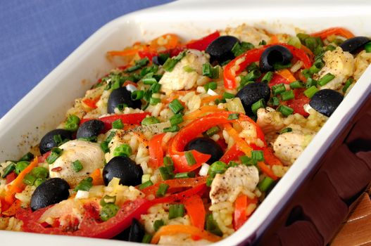 Baked rice with chicken, vegetables and olives in a saucepan