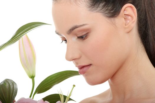 Portrait of the attractive girl without a make-up, with lily flower in hand, isolated on white background 