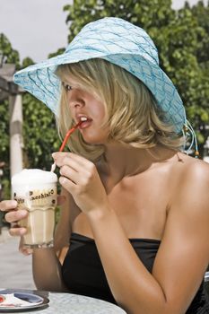 Young woman eating ice cream in a latte macchiato