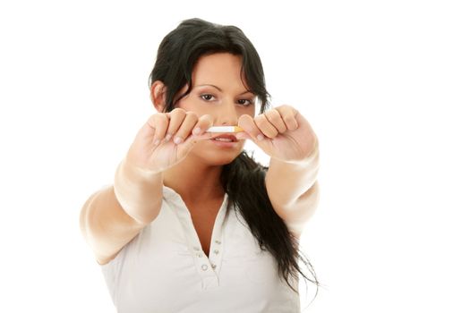 Young woman quiting smoking, isolated on white - focus on hand