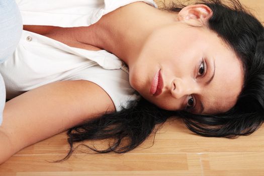 A worried and afraid young woman sitting on the flor.