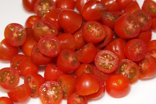 A pile of chopped of red cherry tomatoes.
