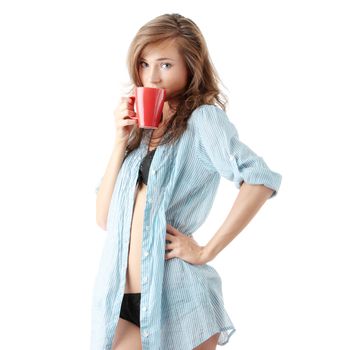 The beautiful young woman drinks morning coffee or tea