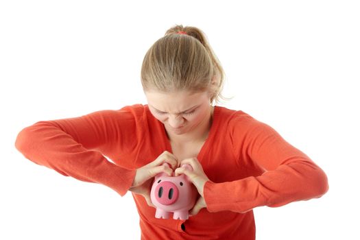 Young blond woman trying to get money from her piggy bank, isolated on white background