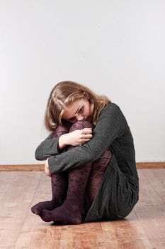 Sad or depressed woman sitting on the flor