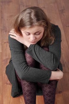 Sad or depressed woman sitting on the flor