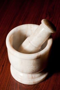 Marble mortar and pestle on dark wood background