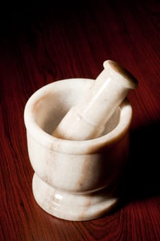 Marble mortar and pestle on dark wood background