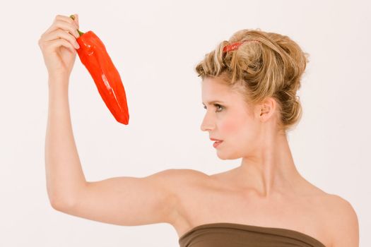 Blonde woman in brown dress with chili peppers and in hand