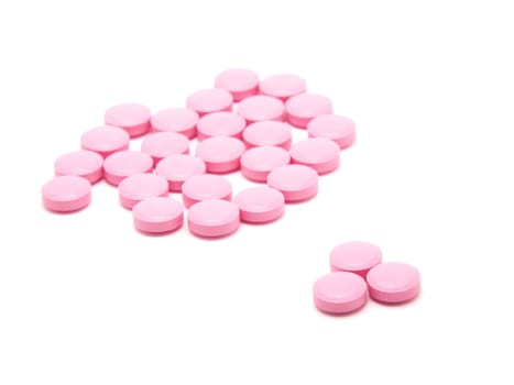 Pink tablets on a white background