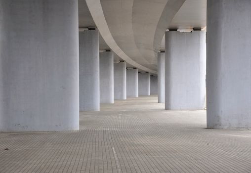 view on the road under concrete road bridge with column