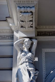 White statue of women holding building roof