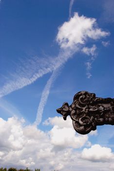 Sky with many clouds and religion item in front of it.