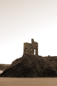 ballybunion castle on the rocks in the west coast of ireland in sepia
