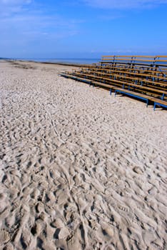 Blue empty benches near the sea in sunny day