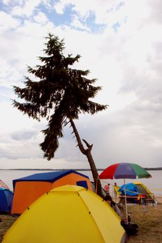 Camping with many tents near the huge blue lake