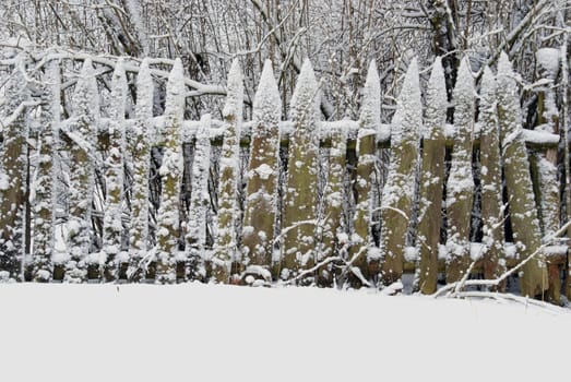 Snow draws ornaments on old farmhouse fence