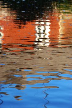 Colorful reflections in the water reminds painting stired by the wind.