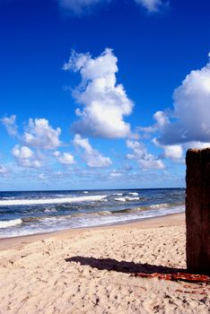 Summer morning cumulus over the sea and sandy coast with the object shadow