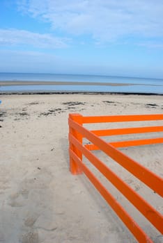 Orange decorative fence on the beach sand
