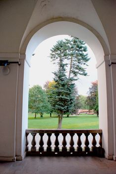 Park landscare through an arch of an old castle